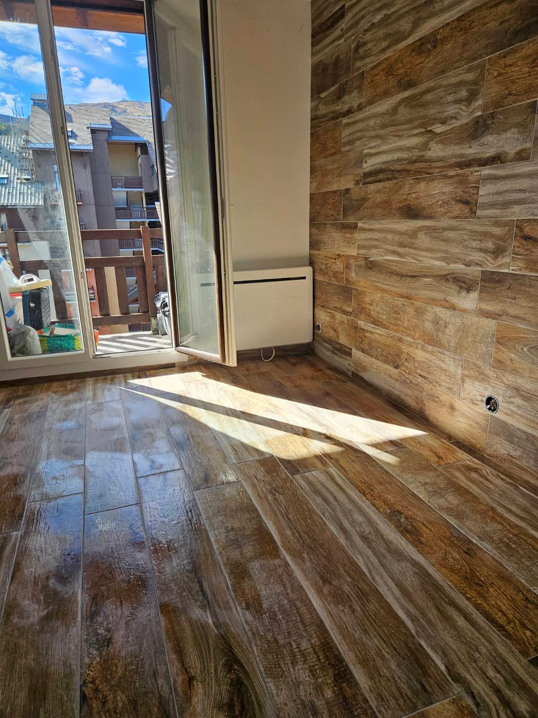 Sol et mur habillés en carrelage imitation bois dans une pièce rénovée